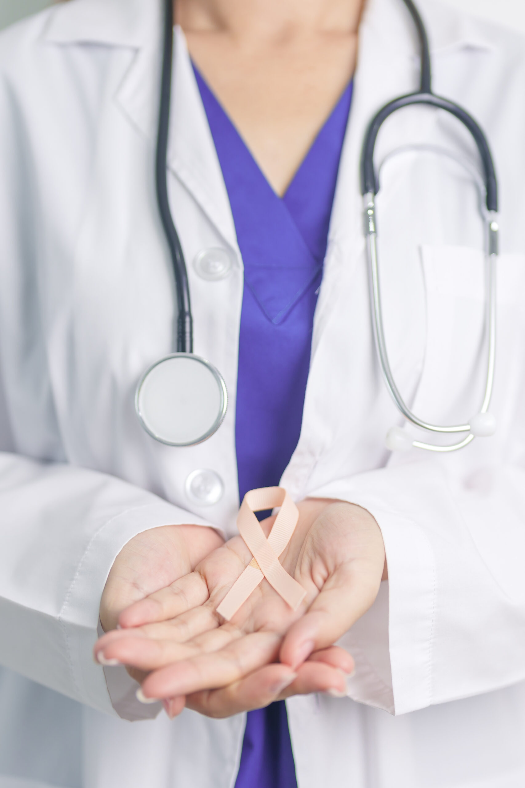 Doctor holding Peach Ribbon for September Uterine Cancer Awarene