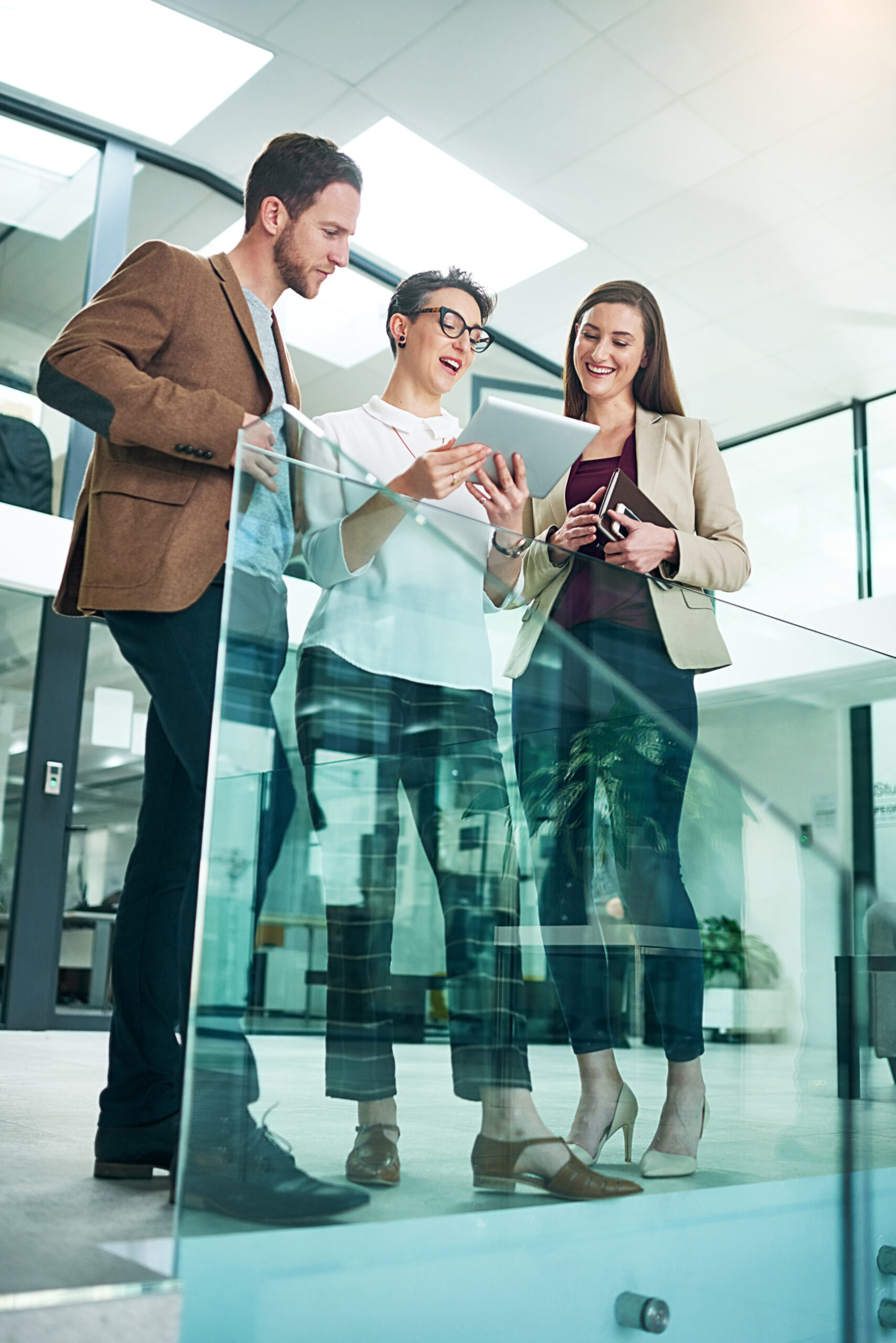 group-people-conversation-with-tablet-modern-office-lens-flare-collaboration-reading-report-tech-agency-team-by-railing-with-idea-discussion-strategy-planning-meeting