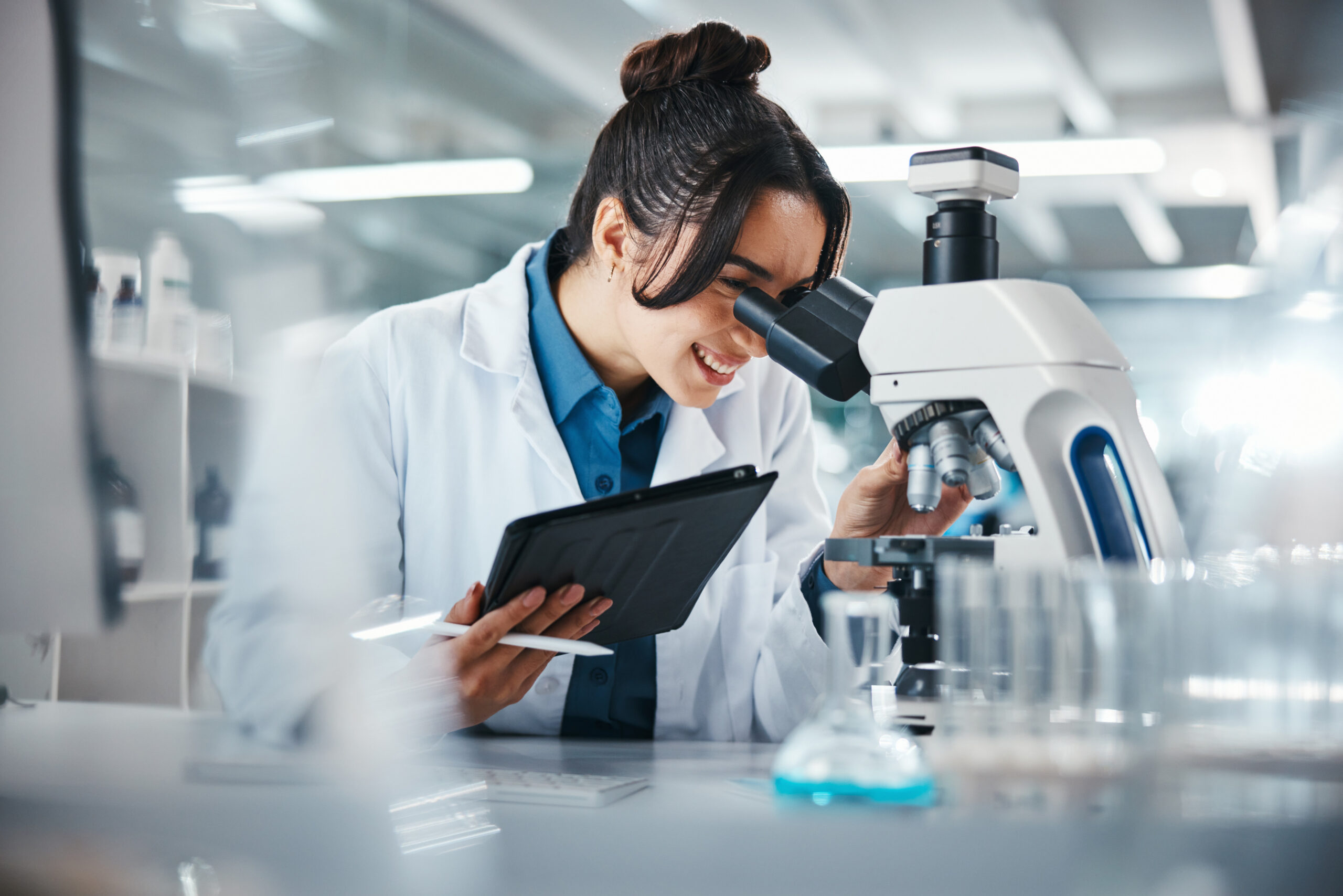 scientist-woman-microscope-with-tablet-lab-experiment-research-medical-data-science-information-smile-researcher-digital-biotechnology-study-feedback-vaccine-solution